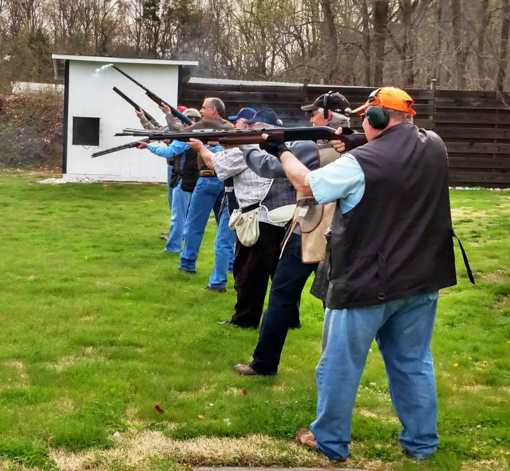 Line of shotgun shooters firing together at the monthly fun shoot