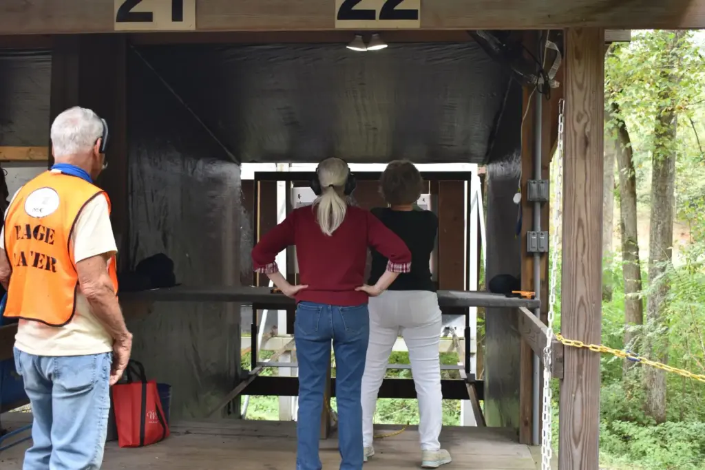 Range Master in an orange vest with shooters on the line